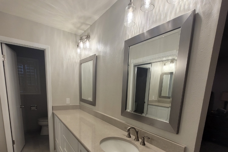 Bathroom with large mirrors and granite countertop