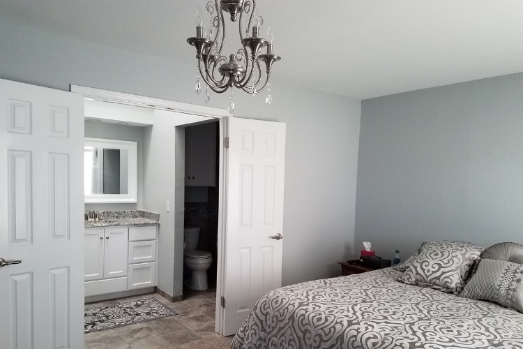 Bedroom and bathroom with tile and carpet flooring