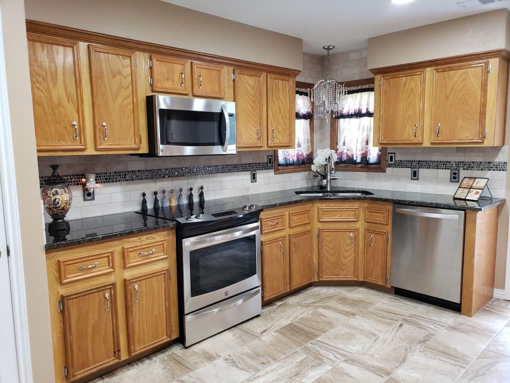 beautiful luxurious kitchen with black granite countertops and light colored tiled floor