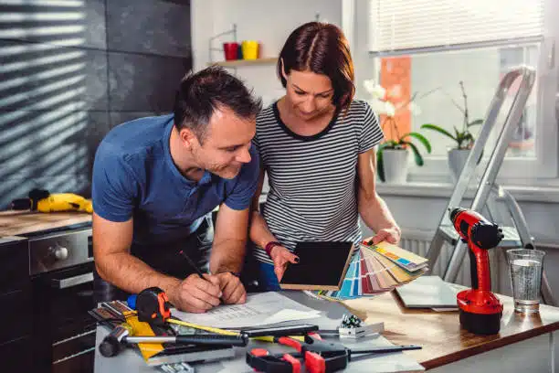 Couple reviewing color swatches and design plans for a home renovation.