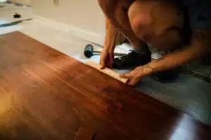 Crop man installing vinyl flooring